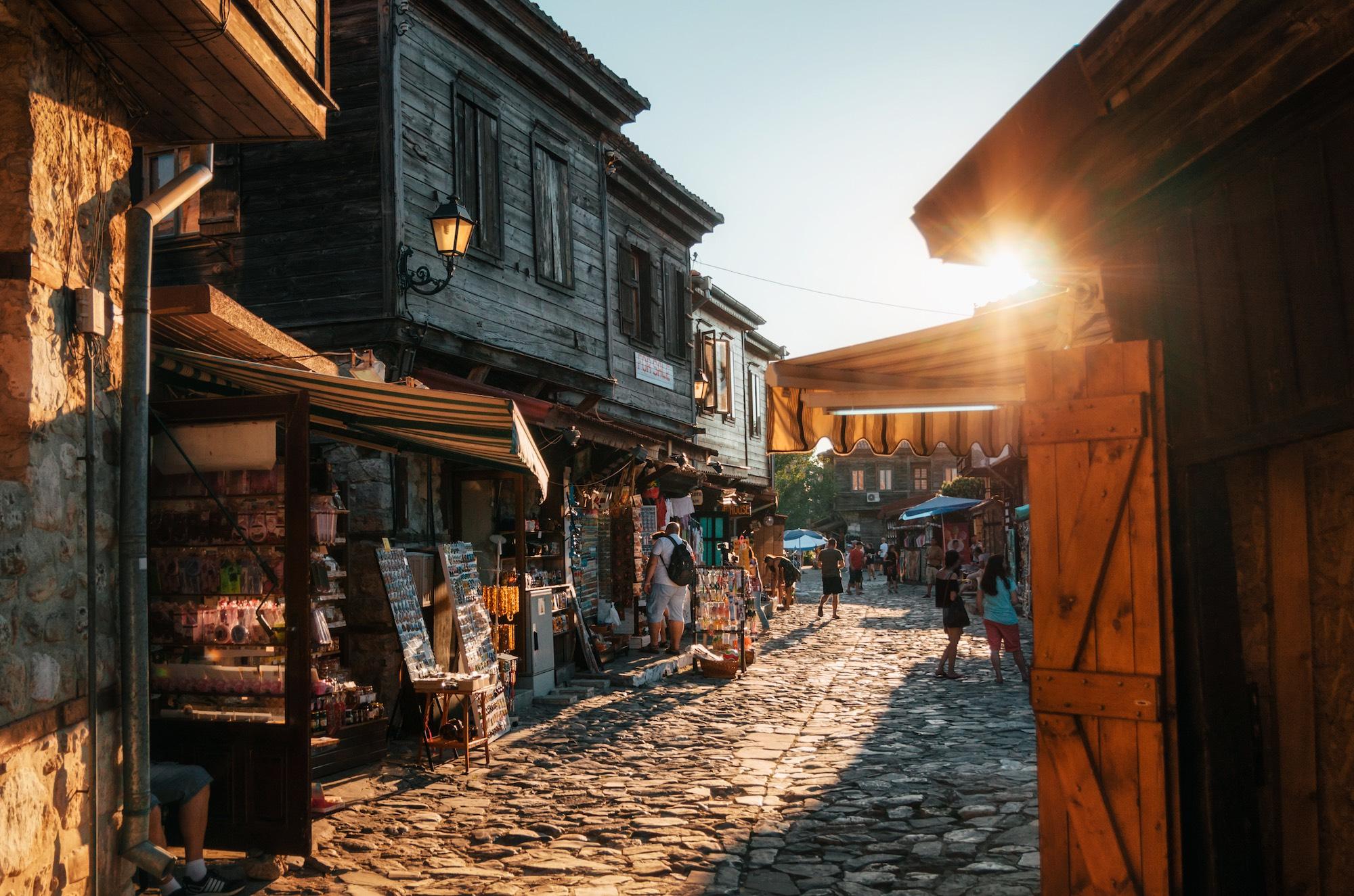 144607ee-cb1f-4eb8-9c95-0c5e1270cfdf-people-walk-through-pedestrian-cobblestone-streets-of-ancient-nessebar-with-cafe-restaurant-and-souvenir-shops-andrei-bortnikau-shutterstock_595716233-2000